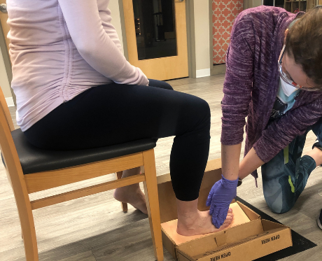 Girl Fit physical therapists fitting for custom orthotics. 